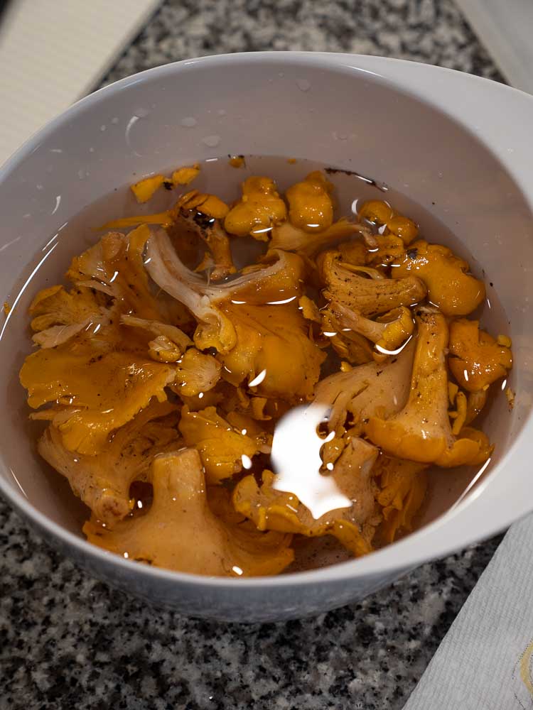 Chanterelles being soaked in a mixing bowl